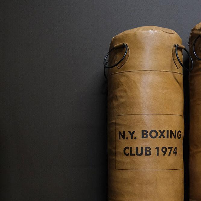 Brun boxningssäck i läder med texten N.Y. Boxing Club 1974 – maskulin inredningsdetalj i industriell stil.