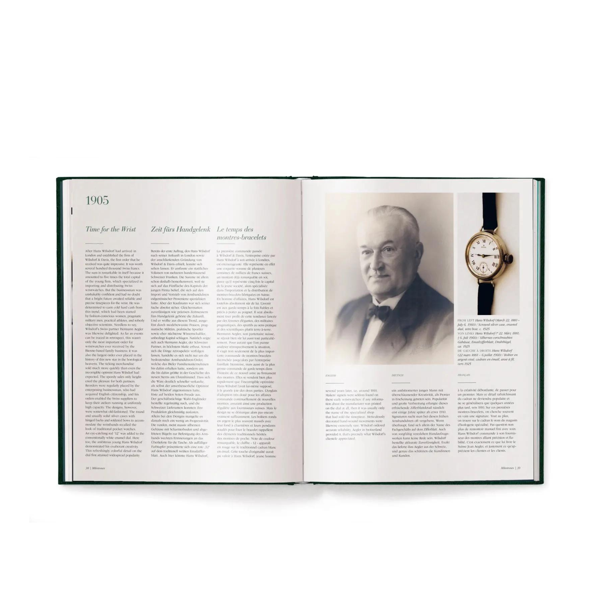 En öppen bok med titeln "The Watch Book Rolex – 3rd Edition: En Omfattande Guide till Rolex" av New Mags, som visar en sida daterad 1905, har ett svartvitt porträtt av en äldre man i kostym och fluga till höger . Bredvid honom finns ett vintage Rolex-armbandsur. Den vänstra sidan innehåller text i flera kolumner tillsammans med en liten rubrik.