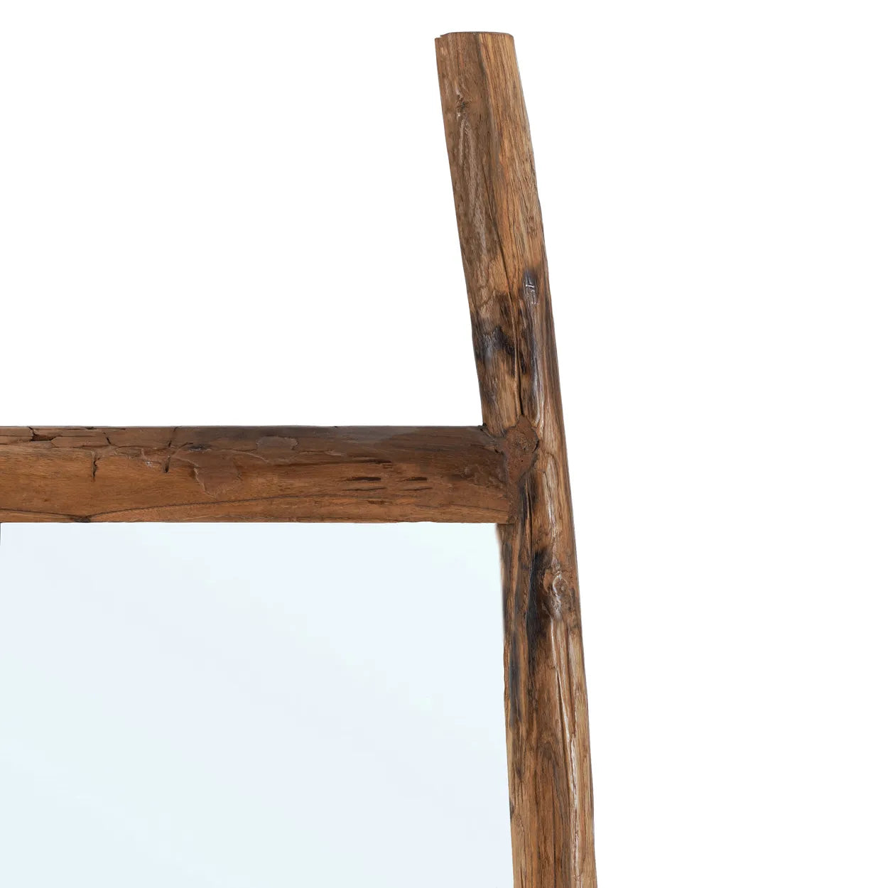 Närbild av det övre hörnet av Fabulook Fristående Spegel av bazar bizar. Dess rustika träram har en elegant design med slitet trä, synliga ådringar och kvistar för en naturlig, strukturerad look mot en vanlig vit bakgrund.