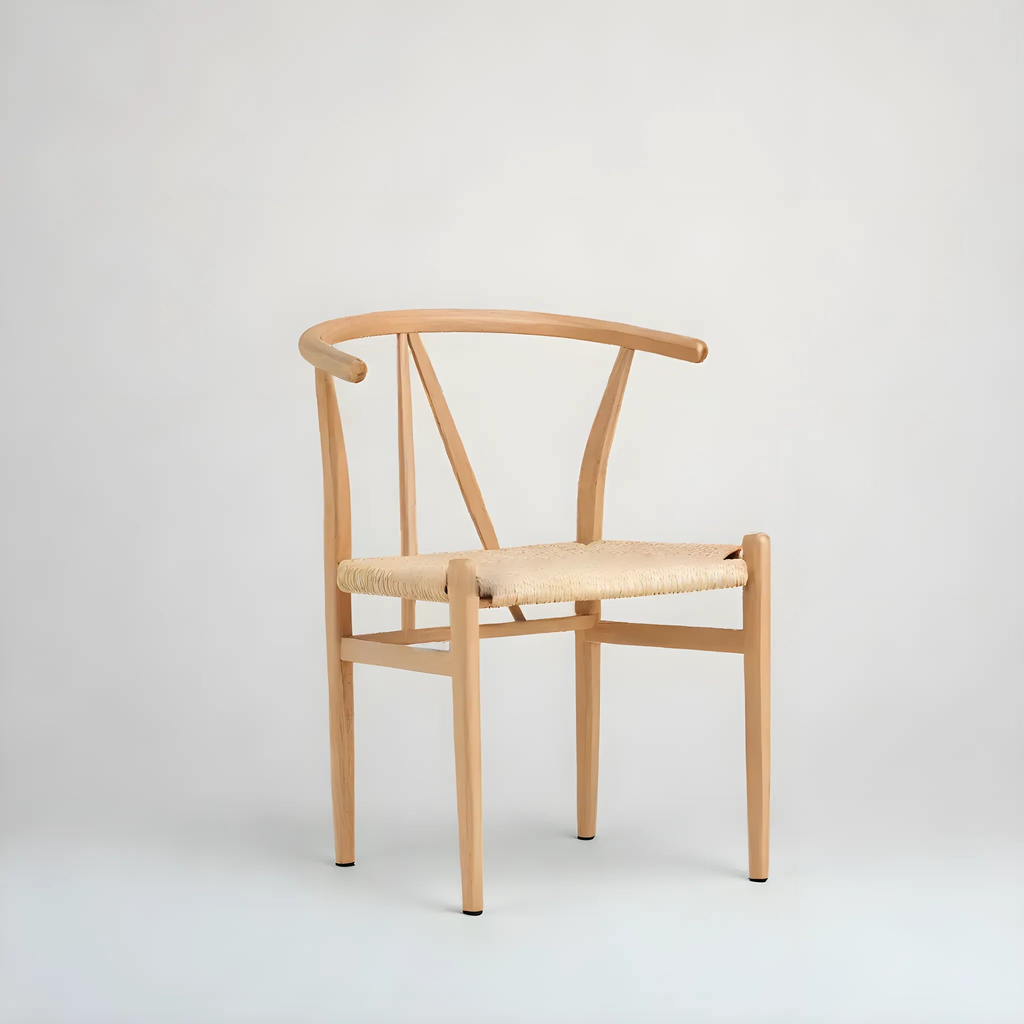 The Alfons matstol från Venture Home erbjuder naturlig elegans med en modern touch, böjd rygg, Y-formade stålben och vacker flätad sits - här mot en enkel ljusgrå bakgrund.